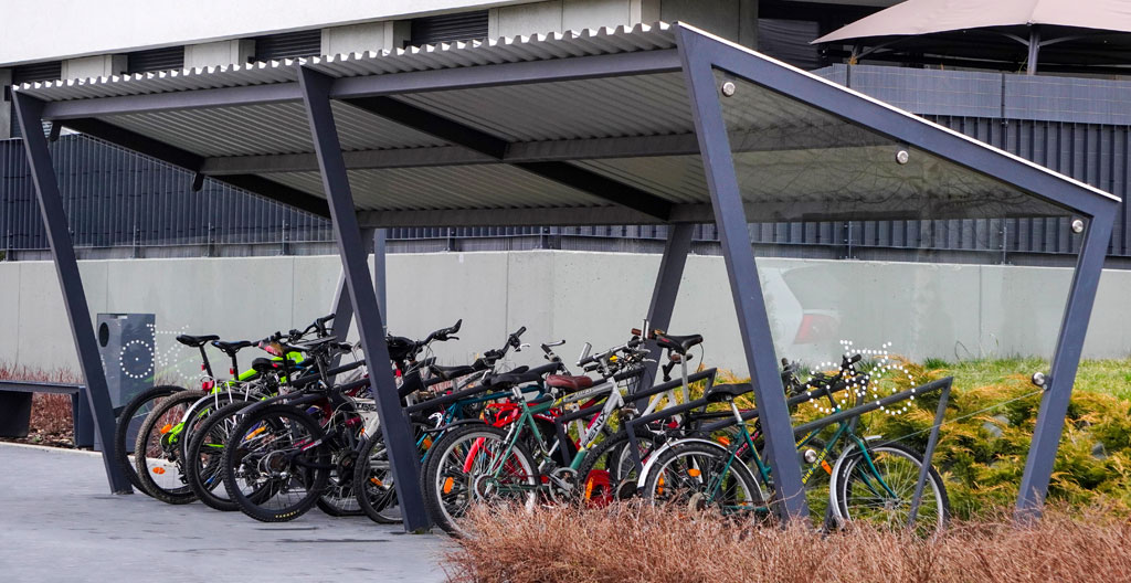 Agent municipal observant un cheminement piéton près d'un stationnement vélo